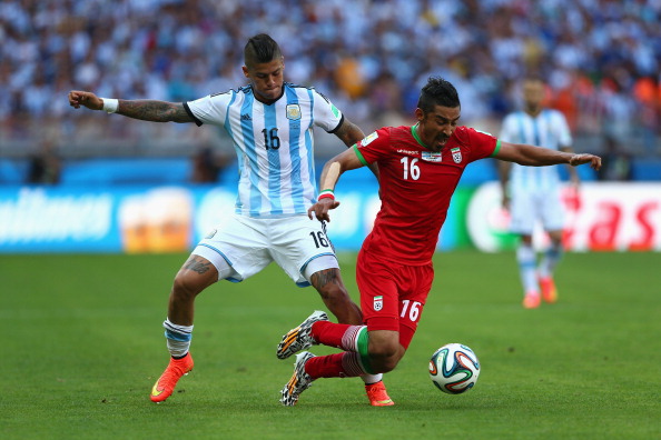 BELO HORIZONTE, BRAZIL - JUNE 21: Marcos Rojo of Argentina challenges Reza Ghoochannejhad of Iran during the 2014 FIFA World Cup Brazil Group F match between Argentina and Iran at Estadio Mineirao on June 21, 2014 in Belo Horizonte, Brazil. (Photo by Quinn Rooney/Getty Images)